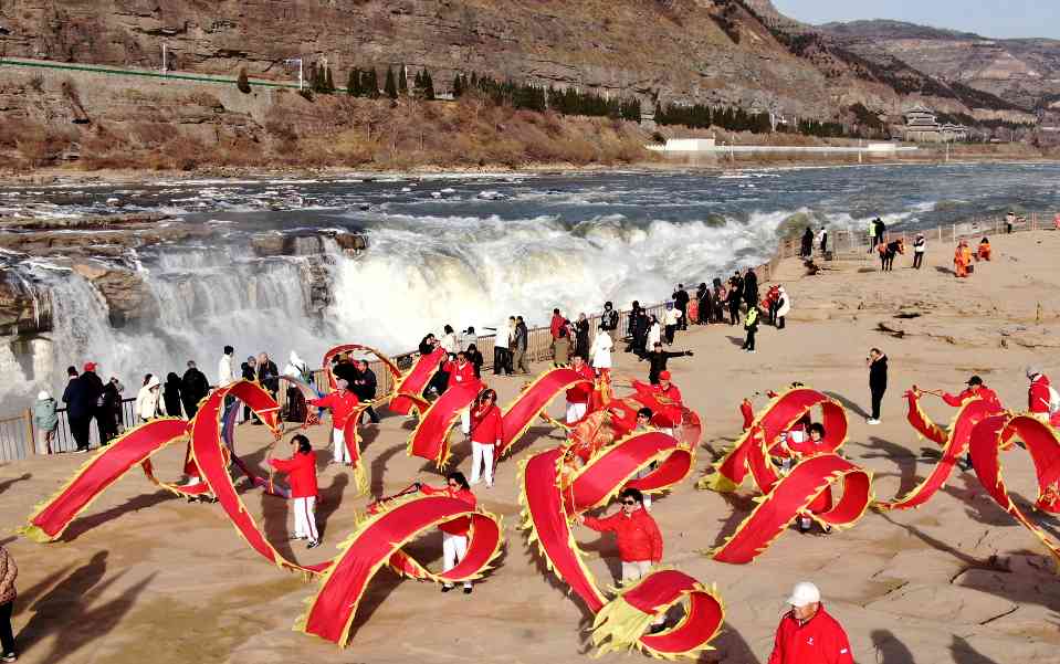 壶口瀑布岸边舞龙表演吸引游客｜冬季旅游全攻略(图1)